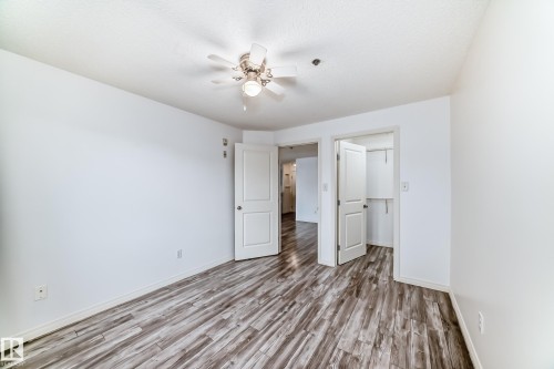 Interior space featuring wood-finish flooring, white walls, and a ceiling fan with integrated lighting - 210 2305 35A Avenue, Edmonton, AB - Indoor Photo Showing Other Room