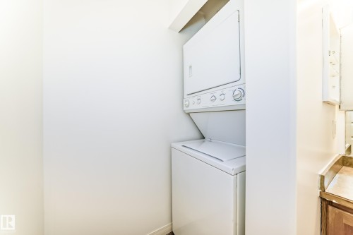 Dedicated laundry area featuring a stacked washer and dryer unit - 210 2305 35A Avenue, Edmonton, AB - Indoor Photo Showing Laundry Room