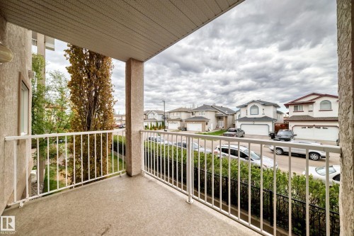 Private balcony with concrete flooring, stucco exterior, and white metal railings - 210 2305 35A Avenue, Edmonton, AB - Outdoor With Exterior