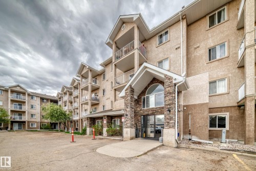Multi-story residential building featuring a stucco exterior with stone facade accents - 210 2305 35A Avenue, Edmonton, AB - Outdoor With Facade