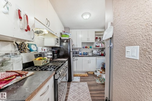 The kitchen features white cabinetry and a gas range - 7723 82 Avenue, Edmonton, AB - Indoor Photo Showing Kitchen