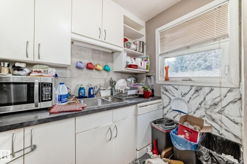 Kitchen featuring white cabinetry, a double basin sink, a window with blinds, and a dishwasher - 7723 82 Avenue, Edmonton, AB - Indoor Photo Showing Kitchen With Double Sink