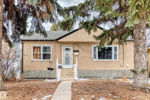 The property features an exterior with stucco siding and a concrete pathway leading to the front entrance - 7723 82 Avenue, Edmonton, AB - Outdoor