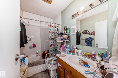 Bathroom featuring a vanity with an integrated sink and a large wall-mounted mirror - 7723 82 Avenue, Edmonton, AB - Indoor Photo Showing Bathroom