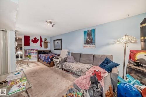 This living space features light blue walls and neutral carpeting - 7723 82 Avenue, Edmonton, AB - Indoor