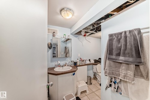 Bathroom featuring a single basin vanity with a built-in cabinet and a wall-mounted medicine cabinet - 7723 82 Avenue, Edmonton, AB - Indoor Photo Showing Bathroom