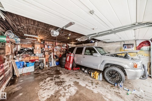 A spacious garage featuring a wood paneled ceiling and a garage door with overhead tracks - 7723 82 Avenue, Edmonton, AB - Indoor Photo Showing Garage
