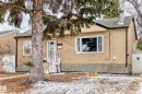 The property features a stucco exterior with a stone-look foundation, a shingled roof, and a mature tree in the front yard - 7723 82 Avenue, Edmonton, AB  - Outdoor 