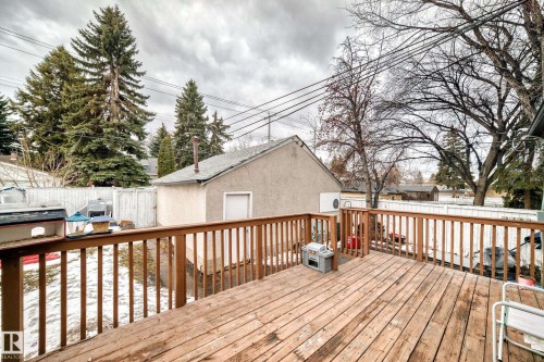 The property includes a wooden deck with a railing, a fenced yard, and a detached building with an external door - 7723 82 Avenue, Edmonton, AB - Outdoor With Deck Patio Veranda With Exterior