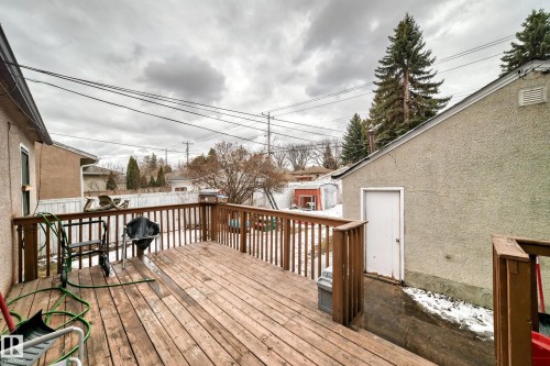 The property features a wooden deck with a matching wooden railing, providing outdoor living space - 7723 82 Avenue, Edmonton, AB - Outdoor With Deck Patio Veranda With Exterior