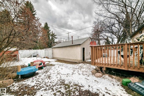 The property features a fenced yard with a detached garage and a wood deck - 7723 82 Avenue, Edmonton, AB - Outdoor