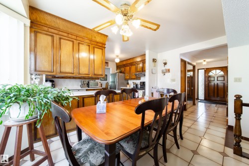 Dining area featuring a wood-finish table, dark wood chairs, and a ceiling fan with integrated lighting - 8509 39B Avenue, Edmonton, AB - Indoor Photo Showing Dining Room