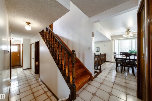 Tiled entryway with dark wood staircase and balusters - 8509 39B Avenue, Edmonton, AB - Indoor Photo Showing Other Room