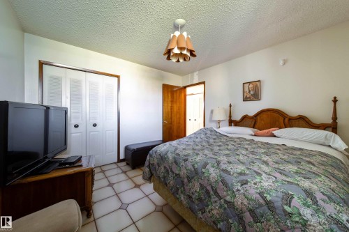 Bedroom featuring tile flooring, white walls, and a decorative ceiling light fixture - 8509 39B Avenue, Edmonton, AB - Indoor Photo Showing Bedroom