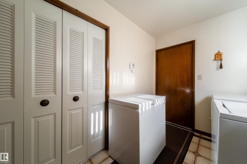White louvered bifold doors with bronze hardware complement the light-toned walls - 8509 39B Avenue, Edmonton, AB - Indoor Photo Showing Laundry Room