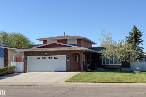 Residential exterior featuring brick and siding finishes, a double-car garage with a concrete driveway, and a front lawn with mature trees - 8509 39B Avenue, Edmonton, AB - Outdoor With Facade