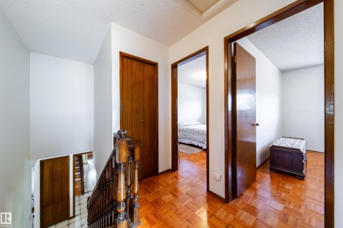 Hallway featuring rich wood-finish parquet flooring and white walls - 8509 39B Avenue, Edmonton, AB - Indoor Photo Showing Other Room