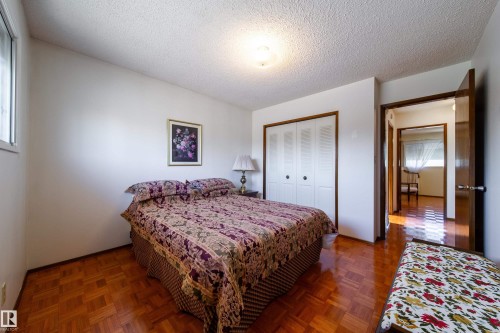 Bedroom featuring parquet wood-finish flooring, white walls, and a textured ceiling - 8509 39B Avenue, Edmonton, AB - Indoor Photo Showing Bedroom