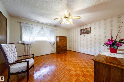 Room featuring wood-finish parquet flooring and a textured ceiling - 8509 39B Avenue, Edmonton, AB - Indoor