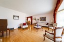Expansive living space featuring wood-finish flooring, white wall tones, and recessed floor vents - 8509 39B Avenue, Edmonton, AB  - Indoor Photo Showing Living Room 