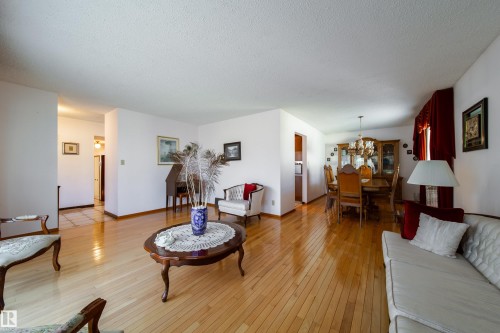 Spacious interior featuring hardwood flooring, white walls, and a dining area with a chandelier - 8509 39B Avenue, Edmonton, AB - Indoor Photo Showing Living Room