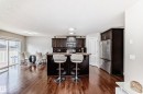 Open-concept kitchen and dining area featuring rich wood-finish flooring - 6419 18 Avenue, Edmonton, AB  - Indoor 