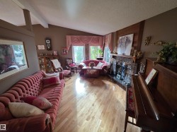 Spacious interior featuring wood-finish flooring and a vaulted ceiling with exposed beams - 