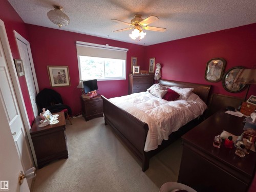 Bedroom featuring a window with a roller blind, wall-to-wall carpeting, and a ceiling fan with integrated lighting - 25 Mcnabb Crescent, Stony Plain, AB - Indoor Photo Showing Bedroom
