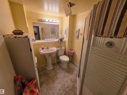 Lower Level 3 Pc Bathroom featuring a pedestal sink, wall-mounted mirror with overhead lighting, and a shower enclosure - 