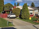 Single-story residence featuring a carport, concrete driveway, and front lawn landscaping with mature trees - 25 Mcnabb Crescent, Stony Plain, AB  - Outdoor 