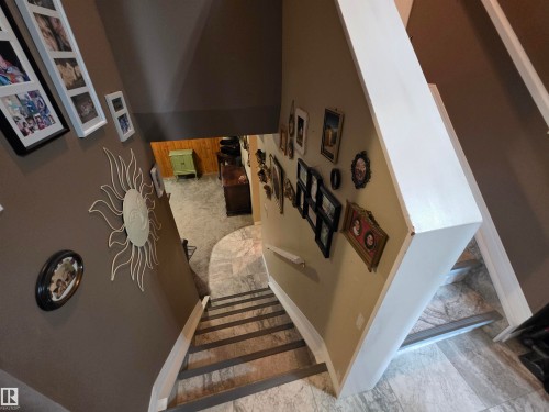 Staircase with tile-finish risers, a light-toned wood-finish handrail, and a neutral wall color - 25 Mcnabb Crescent, Stony Plain, AB - Indoor Photo Showing Other Room