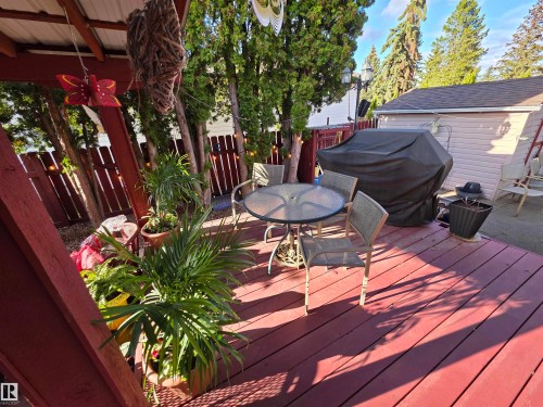 Spacious outdoor deck featuring red-stained wood planks and a partial overhead cover - 25 Mcnabb Crescent, Stony Plain, AB - Outdoor With Deck Patio Veranda With Exterior