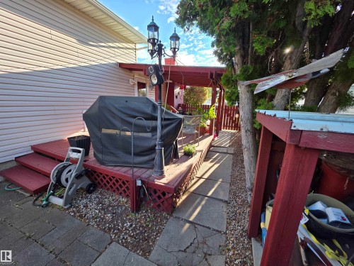Red-stained wood deck featuring lattice skirting and a lamp post - 25 Mcnabb Crescent, Stony Plain, AB - Outdoor With Deck Patio Veranda With Exterior