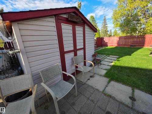 Detached storage shed with white siding and red trim - 25 Mcnabb Crescent, Stony Plain, AB - Outdoor With Exterior