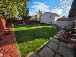 Expansive lawn area with a defined stone paver pathway - 