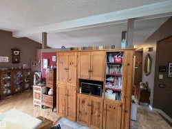 Large built-in wood cabinetry with integrated shelving and microwave alcove - 