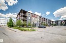 Multi-story building featuring a blend of red, cream, and stone-look exterior finishes - 210 3315 James Mowatt Trail Sw, Edmonton, AB  - Outdoor With Balcony With Facade 