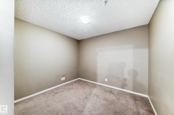 Carpeted room with neutral wall tones and a textured ceiling - 