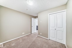 Neutral-toned walls complement the brown carpet flooring and white baseboards - 