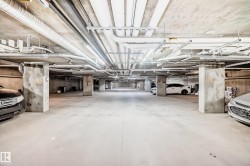 Underground parking garage featuring concrete flooring and exposed ceiling ductwork - 