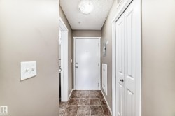 Foyer with square tile flooring, white entry door, and bi-fold closet doors - 