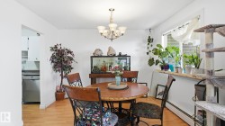 Dining area featuring wood-finish flooring, a multi-bulb chandelier, and a bright window with a deep sill - 