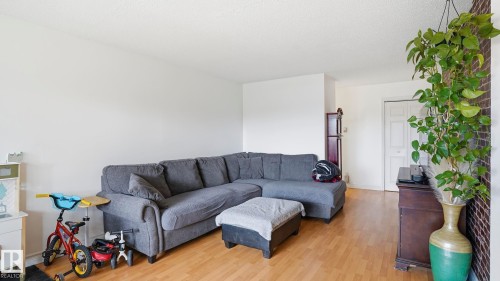 Bright living area featuring wood-finish flooring and white walls - 105 5125 Riverbend Road, Edmonton, AB - Indoor Photo Showing Living Room