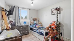 Bright room with light gray walls and wood-finish flooring - 