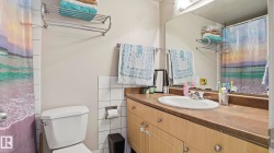 Bathroom featuring a single vanity with an integrated sink, a large wall-mounted mirror, and overhead lighting - 