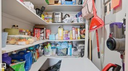 Built-in pantry shelving featuring white L-shaped shelves providing substantial storage - 