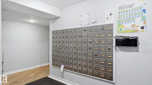 Communal mailboxes within a building corridor featuring light wood-finish flooring - 105 5125 Riverbend Road, Edmonton, AB - Indoor