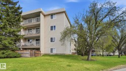 Multi-story building featuring light-colored siding and multiple private balconies with white railings - 