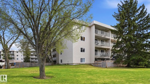 Multi-story building featuring light-colored horizontal siding and multiple private balconies with metal railings - 105 5125 Riverbend Road, Edmonton, AB - Outdoor