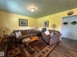 Open concept living area featuring wood-finish flooring and a neutral color palette - 